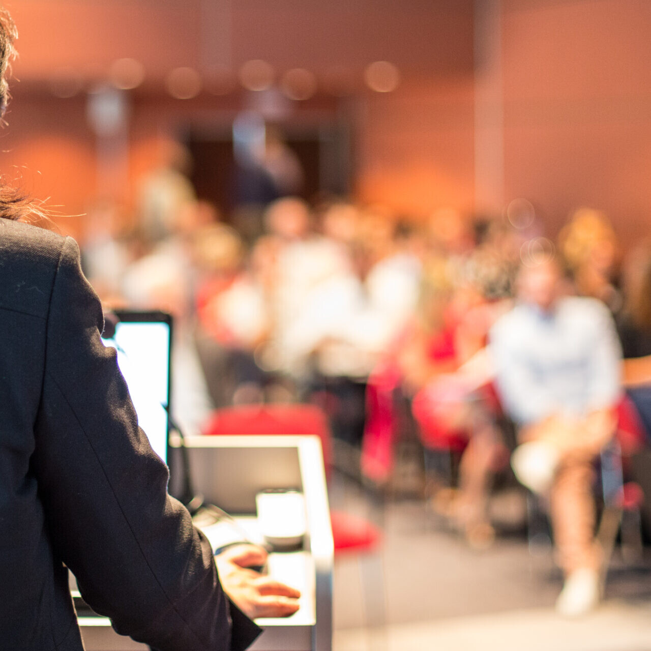 Female public speaker giving talk at Business Event.