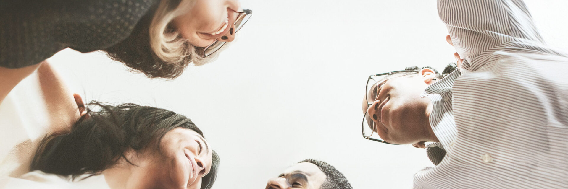 Happy diverse businesswomen huddling in the office